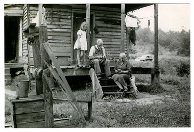 Carving wood on the porch of a mountain home