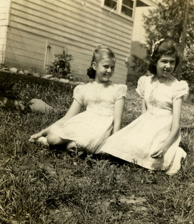 Two girls sitting in yard