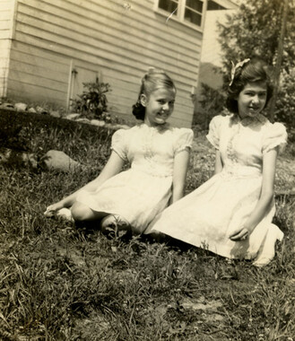 Two girls sitting in yard